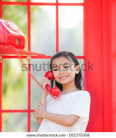 asia girl calling in red in a public phone
