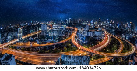 Bangkok city night view with main traffic high way under raining and storm.
