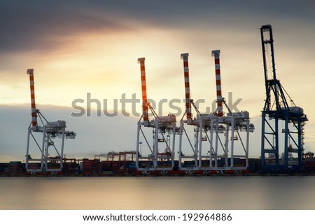 Container Cargo freight ship with working crane bridge in shipyard at dusk for Logistic Import Export background Container Cargo freight ship with working crane bridge in shipyard at dusk for Logistic Import Export background