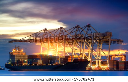Container Cargo freight ship with working crane bridge in shipyard at dusk for Logistic Import Export background