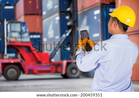 foreman control forklift handling the container box load to big truck selective focust at container box.