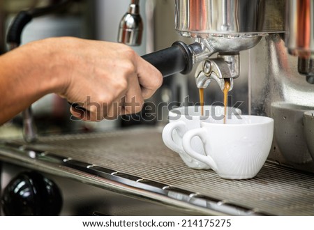 prepares espresso in his coffee shop with hand and close up