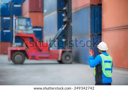 foreman control forklift handling the container box load to big truck