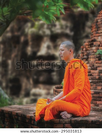 Angkor Wat monk. Ta Prohm Khmer ancient Buddhist temple in jungle forest. Famous landmark, place of worship and popular tourist travel destination in Asia