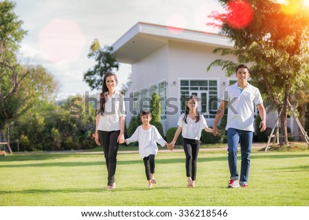 Beautiful family portrait smiling outside their new house with sun light