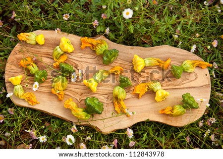 squash blossoms on wooden board with grass background
