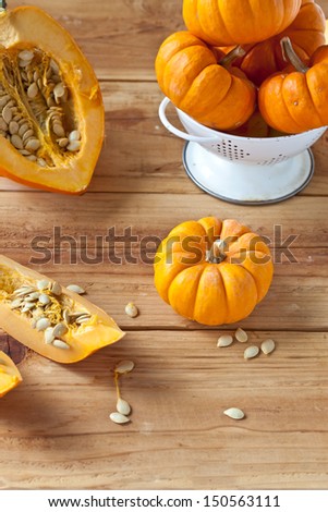 Orange Acorn Squash and Baby Pumpkins on wooden surface.  Also available in horizontal format.