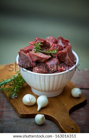Raw Fresh Beef Cubes in a Bowl with Greens