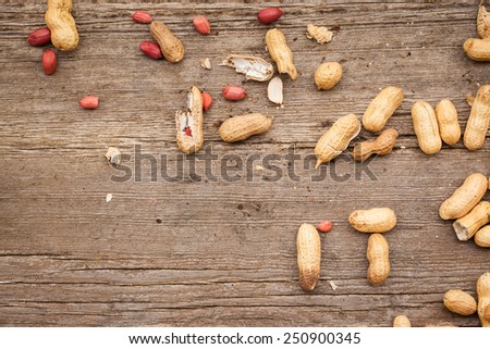 A few peanuts in shells on wood background. Copy space. Also available in vertical format.