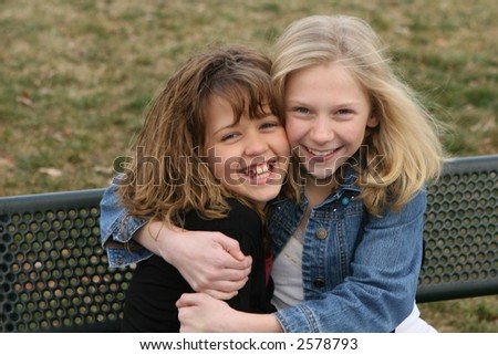 young girl friends smiling and laughing at park