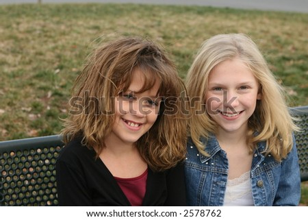 young girl friends smiling at park outside