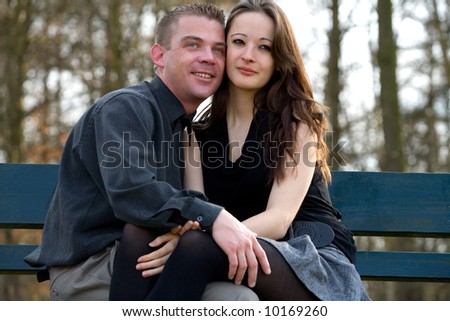 Boyfriend and girlfriend sitting on a park bench