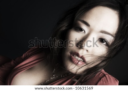 Young chinese girl on a dark background