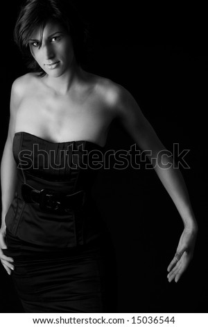 Studio portrait of a tall lady in a black dress on a black background