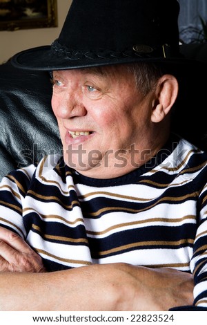 Older man posing with a black cowboy hat