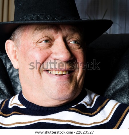 Older man smiling with his black cowboy hat.
