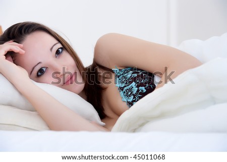Beautiful woman in a bedroom resting and relaxing