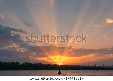 Dusk sun rays over the river. Sunset landscape.