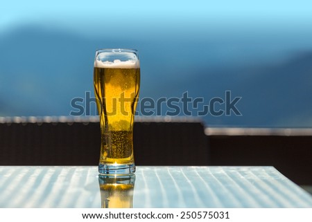 beer glass on the bar table at the open-air cafe in mountains