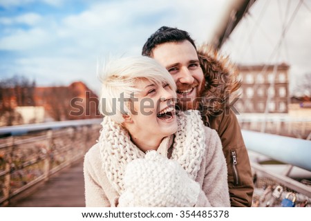 Young couple having fun on city footbridge. Krakow. Poland.