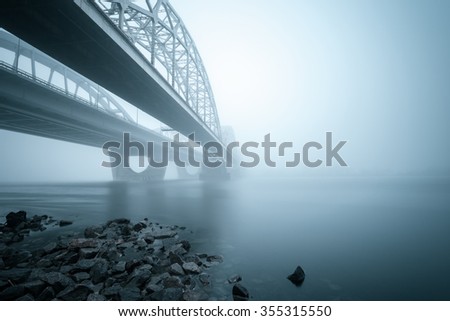Two parallel bridges over foggy river. Coastal landscape on long exposure. Kiev. Ukraine.