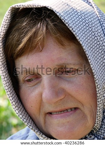 Lovely old woman with scarf in her seventies, close up.