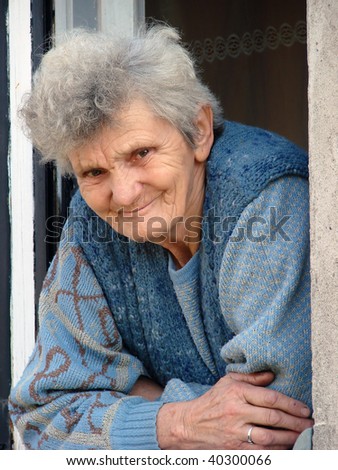 Lonely older woman looking through a window.