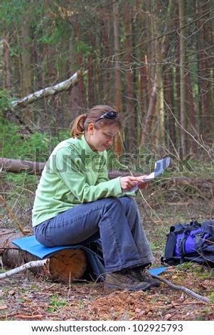backpacker in the woods reading a map, forest near Moscow, Russia