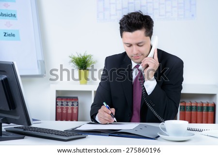 attractive business man in office speaking at telephone