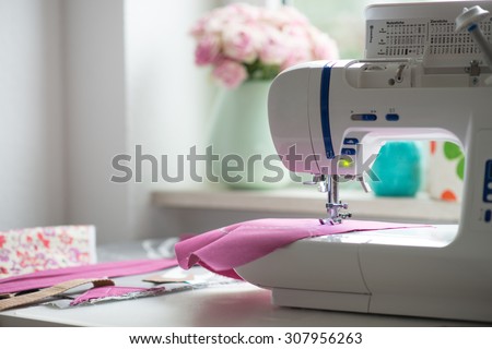 view of sewing room with sewing machine, fabric, flowers and woman