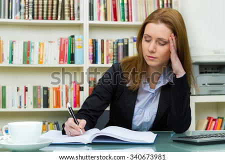 pretty female student with pc and books working in a high school library