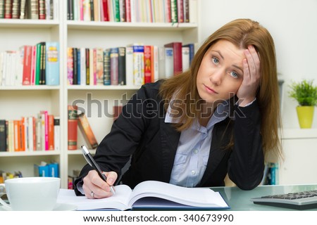 pretty female student with pc and books working in a high school library