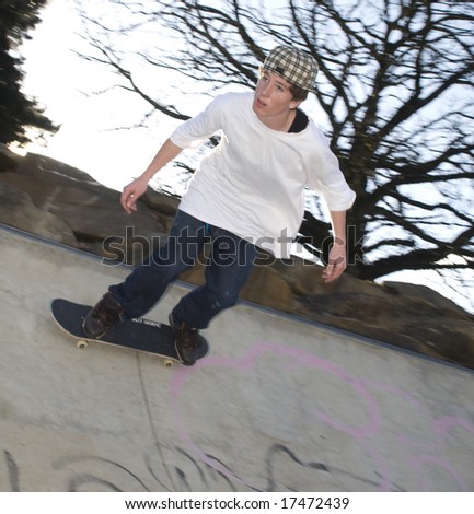 Skate boarder riding along edge of bowl