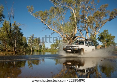 Car driving through river making splash