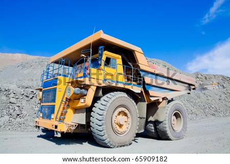 Heavy mining dump truck driving along the opencast