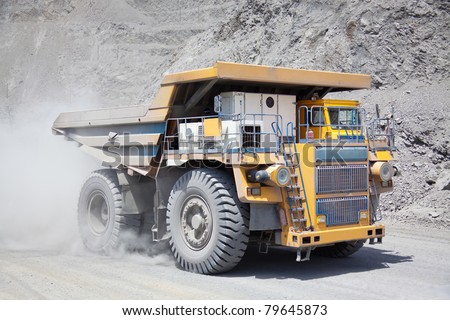 Heavy mining dump truck driving along the opencast
