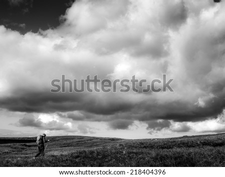 Single Hiker Traveler Walking underneath Dramatic Sky in Black and White