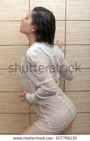 the girl takes a shower in a wet blouse