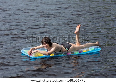 cheerful woman on an air-bed in the lake water