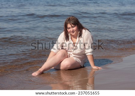 sensual girl in a wet shirt on the beach