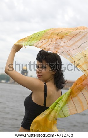 young woman by Petersburg\'s river with flying orange scarf