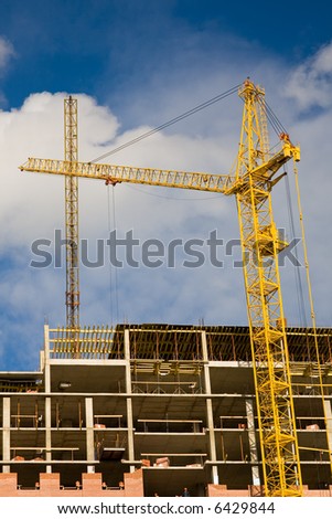 building of a new block of flats by yellow cranes