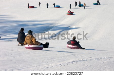 People slide down from a snow hill