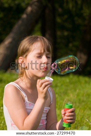 The girl and a soap bubble in sunny day