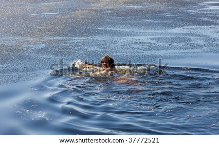 The woman swimming in cold spring water with ice
