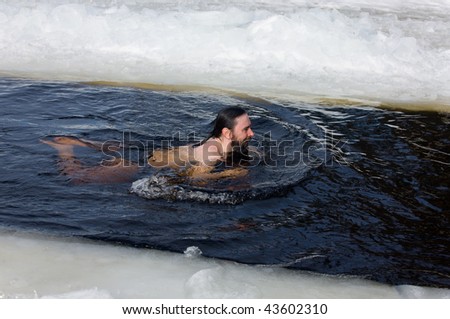 The man swimming in an ice-hole on lake