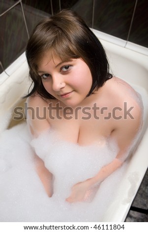 The young girl takes a bath with foam