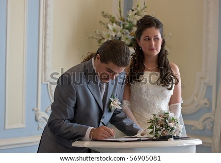 The groom appends the signature in the document of registration of marriage