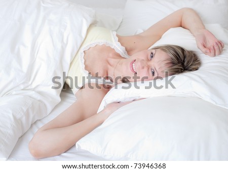The woken up girl in the morning on a bed