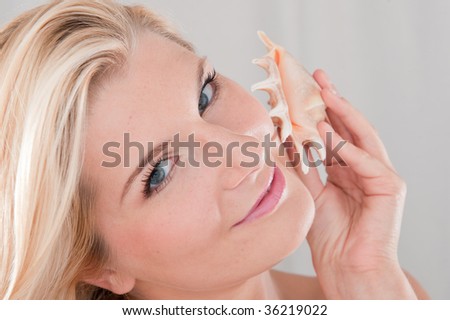 Picture of a young woman with a sea shell after the summer vacation